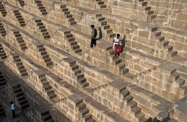 Indian men walk down the steps of the historic Chand Baori stepwell  in Abhaneri village of western Rajasthan state on September 24, 2015. (Photo by Alex Ogle/AFP Photo)