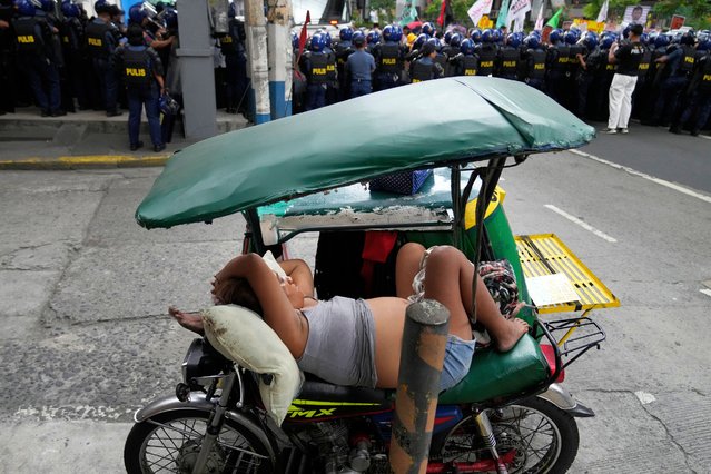 Two people sleep on their tricycle behind a police blockade as protesters tried to march towards the Malacanang presidential palace in Manila, Philippines, Monday, March 17, 2025. (Photo by Aaron Favila/AP Photo)