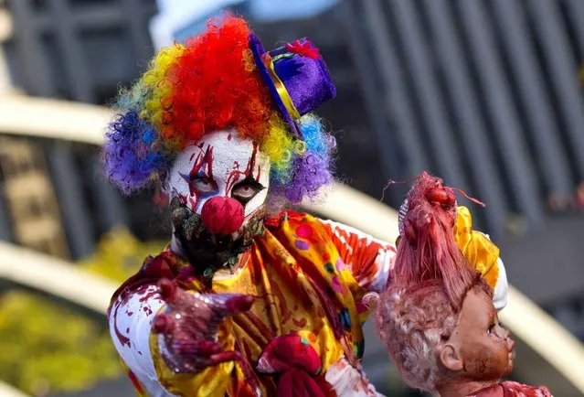 Participants dressed up as zombies pose for photos during the 2014 Toronto Zombie Walk in Toronto, Canada, October 25, 2014. (Photo by Zou Zheng/Xinhua)