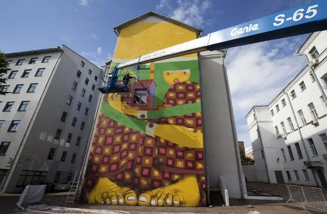 Gustavo and Otavio Pandolfo, painters representing “Osgemeos” (the twins) from Brazil, paint a wall during the street-art festival “Vulica Brazil” ahead of celebrations for the Day of Minsk, in Minsk, Belarus, September 7, 2015. (Photo by Vasily Fedosenko/Reuters)