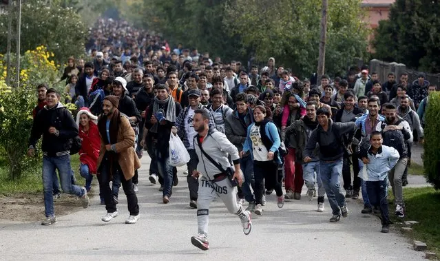 Migrants run towards the Austrian border from Hegyeshalom, Hungary, October 6, 2015. Austria and Germany have committed to backing Greek efforts to secure more EU funds to cope with the influx and to boost staff on the ground. Many of the almost 400,000 migrants who have arrived in Greece this year have later passed through Austria on their way to Germany. (Photo by Leonhard Foeger/Reuters)
