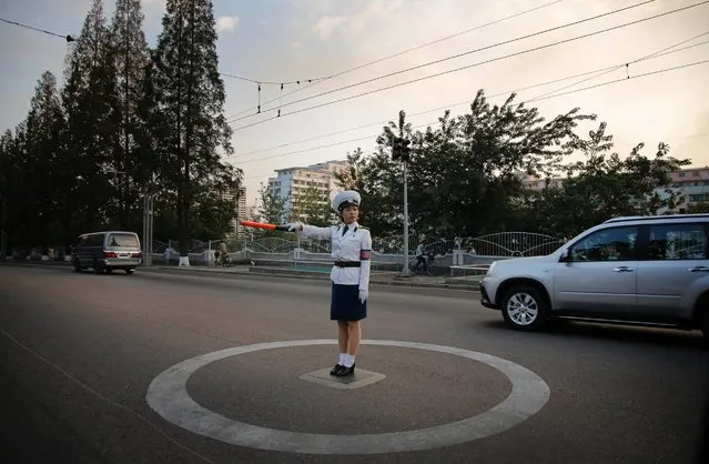 A North Korean traffic police woman directs vehicles at an intersection, Tuesday, September 15, 2015, in Pyongyang, North Korea, as residents commute at the end of the work day. (Photo by Wong Maye-E/AP Photo)