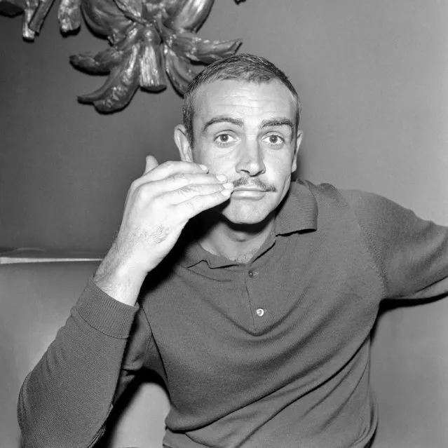 Scottish actor Sean Connery brushes down his new mustache at a reception in London, United Kingdom given to launch his new film on September 1, 1964, and to introduce the facial adornment. The mustachioed actor would star as a court-martial's Regiment Sergeant Major in “The Hill” which was shot at the Boreham Wood film studios in Hertfordshire and on location in Spain. (Photo by Bob Dear/AP Photo)