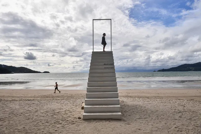 A girl stands on a set of stairs on Patong beach in Phuket on October 1, 2020, which has seen a lack of tourists due to ongoing restrictions relating to the COVID-19 novel coronavirus. (Photo by Lillian Suwanrumpha/AFP Photo)