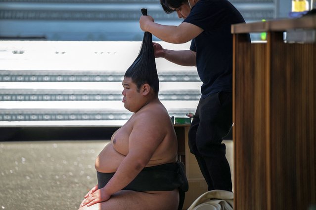 A sumo wrestler has his hair prepared into a “top knot” before taking part in the annual “honozumo”, a ceremonial one-day sumo exhibition for spectators held at Yasukuni Shrine in Tokyo on April 15, 2024. (Photo by Richard A. Brooks/AFP Photo)