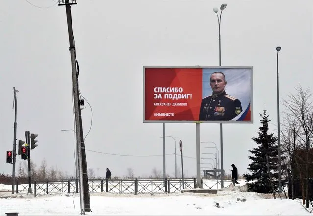 People walk past a billboard depicting a soldier with the slogan “Thanks for the feat” in St. Petersburg, Russia, 06 February 2023. (Photo by Anatoly Maltsev/EPA/EFE)