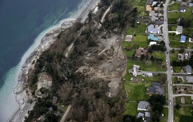 A landslide near Coupeville, Wash, on Whidbey Island severely damaged one home and threatens 33 more in the community overlooking Puget Sound, on March 27, 2013. (Photo by Ted S. Warren/Associated Press)
