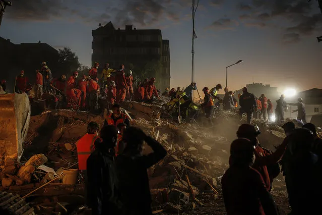 Members of rescue services search for survivors in the debris of a collapsed building in Izmir, Turkey, Monday, November 2, 2020. In scenes that captured Turkey's emotional roller-coaster after a deadly earthquake, rescue workers dug two girls out alive Monday from the rubble of collapsed apartment buildings three days after the region was jolted by quake that killed scores of people. Close to a thousand people were injured. (Photo by Emrah Gurel/AP Photo)