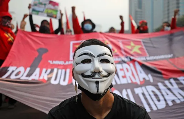 A masked protester pauses during a protest against the new Job Creation Law in Jakarta, Indonesia, Friday, October 16, 2020. Dozens of activists staged the protest demanding that the government revoke the law they say will cripple labor rights. (Photo by Dita Alangkara/AP Photo)
