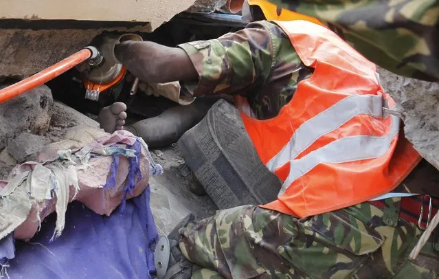 A military personnel attempts to rescue a survivor in the rubble of a collapsed residential building in Makongeni estate  Nairobi December 17, 2014. (Photo by Thomas Mukoya/Reuters)