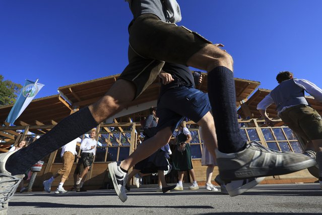 Visitors storm onto the festival meadow for the start of Oktoberfest, on Munich's Theresienwiese, in Germany, Saturday, September 20, 2025. (Photo by Karl-Josef Hildenbrand/dpa via AP Photo)