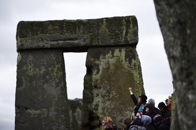 A reveller celebrates as the sun rises during the winter solstice at Stonehenge on Salisbury plain in southern England December 22, 2014. (Photo by Dylan Martinez/Reuters)