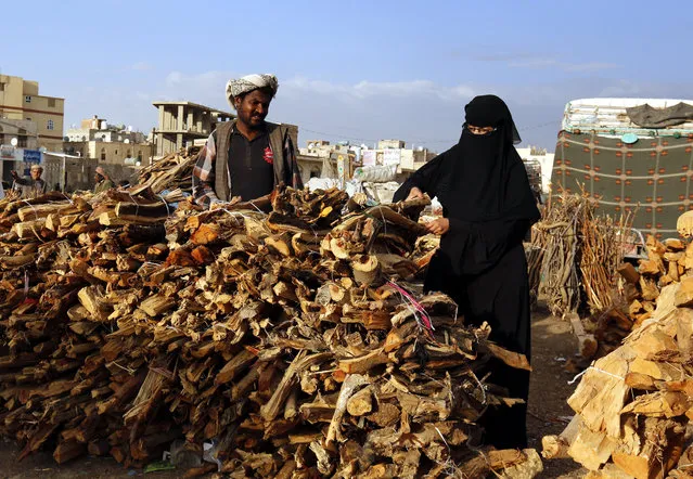 A Yemeni woman (R) buys firewood for cooking as propane gas became unobtainable at a market in Sana'a, Yemen, 15 April 2018 (issued 16 April 2018). Yemen has been experiencing severe shortages of fuel and cooking gas supplies due to three-year conflict in the impoverished country. (Photo by Yahya Arhab/EPA/EFE)