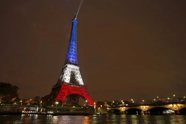The Eiffel Tower is lit with the blue, white and red colours of the French flag in Paris, France, November 16, 2015, to pay tribute to the victims of a series of deadly attacks on Friday in the French capital. (Photo by Benoit Tessier/Reuters)