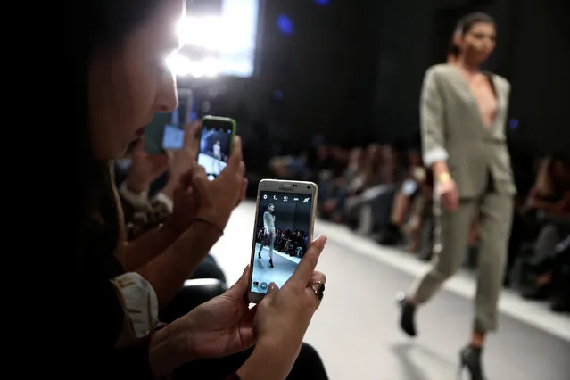 Audience take photos of a model presenting a creation by Greek designer Dimitrios Ordoulidis during the 10th Athens Exclusive Fashion Week in Athens, Greece, October 22, 2016. (Photo by Alkis Konstantinidis/Reuters)