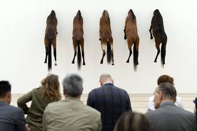 Visitors sit in the exhibition “KAPUTT” (Edition of 3 plus 2 artist's proofs of “Untitled”, 2007, Taxidermied Horses) by Italian artist Maurizio Cattelan in the Fondation Beyeler in Riehen, Switzerland, Monday, June 10, 2013. The exhibition lasts from June 8 to Oct. 6, 2013. (Photo by Georgios Kefalas/AP Photo/Keystone)