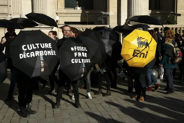 Activists stage a protest outside the Louvre pyramid, calling the museum to cancel its contracts with French oil giant Total and Italian oil company Eni, in Paris, France, December 9, 2015, as the World Climate Change Conference 2015 (COP21) continues at Le Bourget near the French capital. (Photo by Benoit Tessier/Reuters)