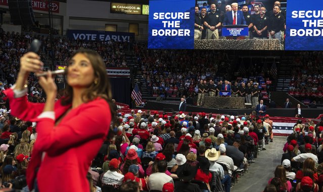 A TV reporter puts on make up while Republican presidential nominee former President Donald Trump delivers a speech during a campaign rally at the Findlay Toyota Arena, Sunday, October 13, 2024, in Prescott Valley, Ariz. (Photo by Rodrigo Abd/AP Photo)