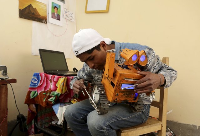 Bolivian student Esteban Quispe, 17, works on a replica of the Wall-E character in Patacamaya, south of La Paz, December 10, 2015. (Photo by David Mercado/Reuters)