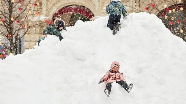 Children play in a snowdrift during a heavy snowfall at the Red square on February 13, 2021 in Moscow, Russia. A record-breaking snowstorm descended on Moscow on February 12, paralysing traffic, grounding flights and straining efforts of local authorities to respond to the “snow apocalypse”. (Photo by Oleg Nikishin/Getty Images)