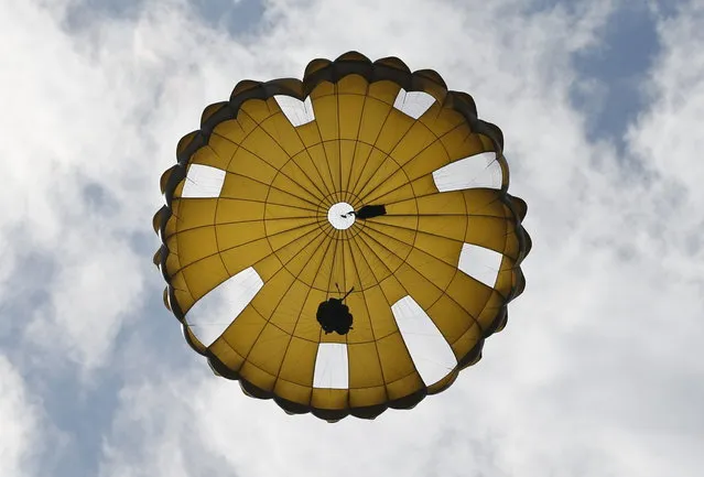 A Japanese Ground Self-Defense Force's 1st Airborne Brigade soldier parachutes from a CH-47 helicopter during their military drill at Higashifuji training field in Susono, west of Tokyo, July 8, 2013. Japan faces increasingly serious threats to its security from China and North Korea, a defence ministry report said on Tuesday, as ruling politicians call for the military to beef up its ability to respond to such threats. (Photo by Issei Kato/Reuters)