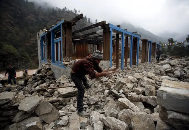 A man clears debris to rebuild a damaged lodge after the earthquake earlier this year in Solukhumbu district, also known as the Everest region, in this picture taken November 28, 2015. (Photo by Navesh Chitrakar/Reuters)
