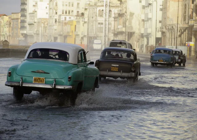 Cars are driven on Havana's flooded seafront boulevard El Malecon as a cold front rolls over Havana, November 2010. (Photo by Desmond Boylan/Reuters)