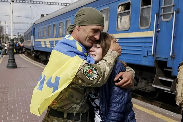 A Ukrainian serviceman embraces his wife after returning from the frontline in the eastern regions, at a railway station in Kiev, Ukraine, September 9, 2015. (Photo by Gleb Garanich/Reuters)