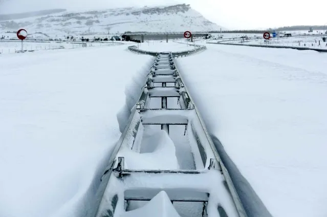 Guard rails on the highway “Autovia A-67” protrude from the snow after a heavy fall near Aguilar de Campoo, Spain on February 5, 2015. (Photo by Cesar Manso/AFP Photo)