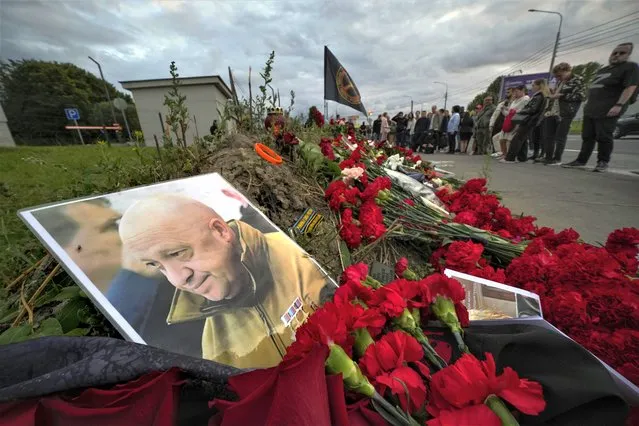 A portrait of the owner of private military company Wagner Group Yevgeny Prigozhin lays at an informal memorial next to the former 'PMC Wagner Centre' in St. Petersburg, Russia, Thursday, August 24, 2023. Russia's civil aviation agency says mercenary leader Yevgeny Prigozhin was aboard a plane that crashed north of Moscow. (Photo by Dmitri Lovetsky/AP Photo)