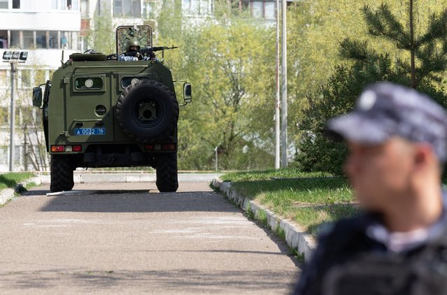 A law enforcement officer points his weapon as he responds to a deadly shooting at School Number 175 in Kazan, Russia on May 11, 2021. (Photo by Artem Dergunov/Reuters)