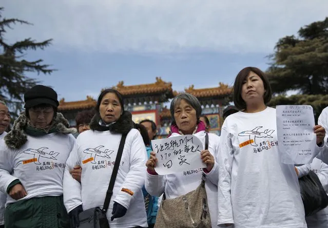 Family members of passengers onboard the missing Malaysia Airlines flight MH370, hold signs inside Yonghegong Lama Temple during a gathering of family members of the missing passengers in Beijing March 8, 2015. Prime Minister Najib Razak said on Sunday Malaysia remains committed to the search for the missing MH370 jetliner a year after it vanished without trace and he is hopeful it will be found. The sign reads: "Bring our relatives aboard Malaysia Airlines flight MH370 home" and the message on the t-shirts read: "Tell me the truth: Where is Malaysia Airlines flight MH370?". 
REUTERS/Kim Kyung-Hoon (CHINA - Tags: TRANSPORT DISASTER)