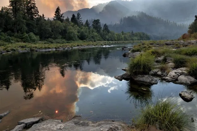 The Umpqua River reflects smoke and heat from the Cougar Creek Wildfire burning in the Tyee Ridge Complex in a rural area northwest of Roseburg Oregon on August 29, 2023. 183 people have been evacuated due to the blazes which were started by a series of lighting strikes on August 24th. The complex has burned about 3,000 acres and is 5% contained. Fifteen helicopter and 904 people are assigned to the fires which are burning in steep mountainous areas. (Photo by Robin Loznak/ZUMA Press Wire/Rex Features/Shutterstock)