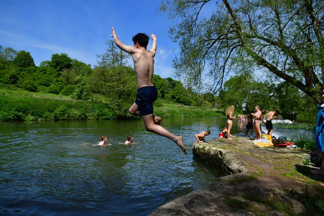 Swimmers dive into the water as they enjoy the hot weather at Warleigh Weir, Bath, United Kingdom on the first day of meteorological summer on Tuesday, June 1, 2021. (Photo by Ben Birchall/PA Images via Getty Images)