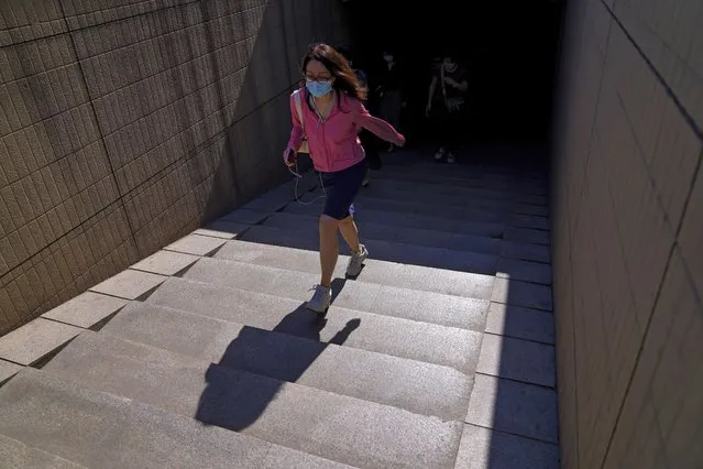 A woman wearing a face mask to help curb the spread of the coronavirus walks out of an underpass tunnel in Beijing, Thursday, June 10, 2021. (Photo by Andy Wong/AP Photo)