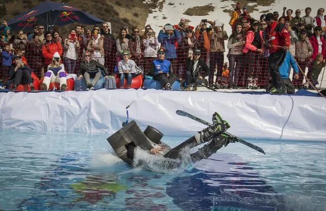 A skier wearing costume dives into a pond as he performs during the Red Bull Jump and Freeze competition at ski resort Shimbulak outside Almaty March 22, 2015. (Photo by Shamil Zhumatov/Reuters)