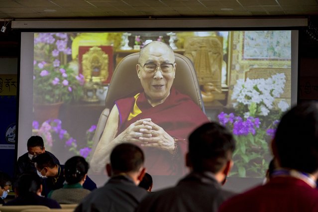 Exile Tibetan government officials watch a message from their spiritual leader the Dalai Lama on a screen during a ceremony to mark the 86th birthday of the Tibetan leader in Dharmsala, India, Tuesday, July 6, 2021. This year, due to the coronavirus pandemic, the celebrations were muted and behind closed doors. (Photo by Ashwini Bhatia/AP Photo)