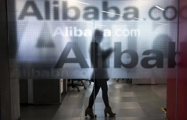 An employee is seen behind a glass wall with the logo of Alibaba at the company's headquarters on the outskirts of Hangzhou, Zhejiang province, in this April 23, 2014 file photo. Hackers in China attempted to access over 20 million active accounts on Alibaba Group Holding Ltd's Taobao e-commerce website using Alibaba's own cloud computing service, according to a state media report posted on the Internet regulator's website. (Photo by Chance Chan/Reuters)
