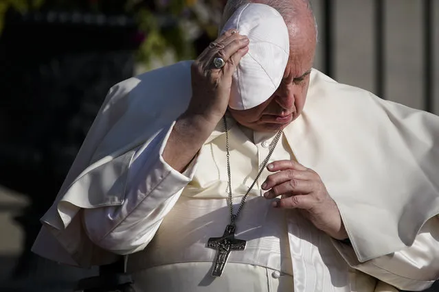 Pope Francis holds onto his skull cap in the wind during his visit to the Citadelle de Quebec, Wednesday, July 27, 2022, in Quebec City, Quebec City, Quebec. Pope Francis is on a “penitential” six-day visit to Canada to beg forgiveness from survivors of the country's residential schools, where Catholic missionaries contributed to the “cultural genocide” of generations of Indigenous children by trying to stamp out their languages, cultures and traditions. (Photo by John Locher/AP Photo)