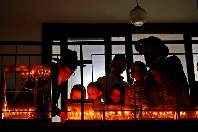 An ultra-Orthodox Jewish family lights candles on the eighth and last night of the holiday of Hanukkah in Bnei Brak, Israel, December 31, 2016. (Photo by Baz Ratner/Reuters)