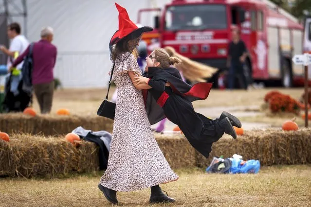 A woman plays with a child at the West Side Hallo Fest, a Halloween festival in Bucharest, Romania, Friday, October 27, 2023. Tens of thousands streamed last weekend to Bucharest's Angels' Island peninsula for what was the biggest Halloween festival in the Eastern European nation since the fall of Communism. (Photo by Vadim Ghirda/AP Photo)