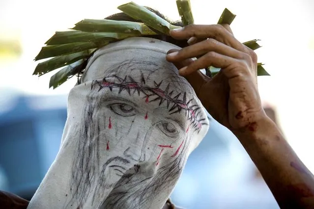 A penitent removes his crown in San Fernando, Pampanga on Maundy Thursday, April 2, 2015. Every year during Holy Week hundreds of penitents perform acts of penance such as self-flagellation, walking barefoot, carrying a cross and self-crucifixion throughout the Philippines, a pre-dominantly Catholic country. (Photo by Mark Cristino/Pacific Press)