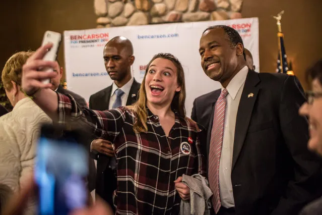 Republican presidential candidate Ben Carson (R) poses for a picture with an audience member following a campaign event at Fireside Pub and Steak House on January 31, 2016 in Manchester, Iowa. (Photo by Brendan Hoffman/Getty Images)