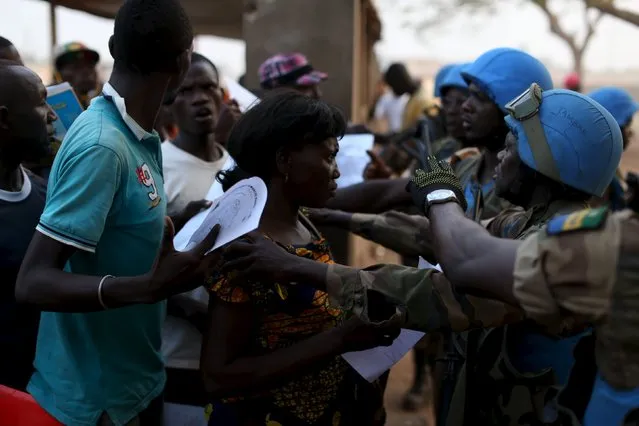 A group of electoral observers are initially refused entry by United Nations peacekeepers as their ballots are taken into another polling station for counting at the end of the presidential and legislative elections, in the mostly muslim PK5 neighbourhood of Bangui, Central African Republic, February 14, 2016. (Photo by Siegfried Modola/Reuters)