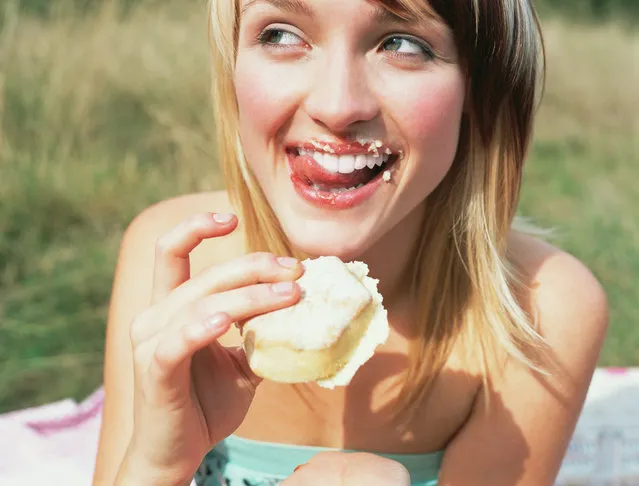 Woman eating a cake. (Photo by Image Source/Getty Images)