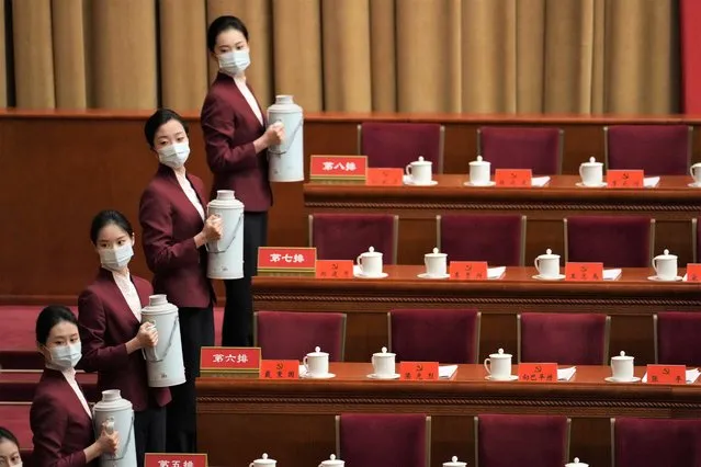Hostesses prepare drinks at the Great Hall of the People before the opening ceremony for the 20th National Congress of China's ruling Communist Party in Beijing, China, Sunday, October 16, 2022. China on Sunday opens a twice-a-decade party conference at which leader Xi Jinping is expected to receive a third five-year term that breaks with recent precedent and establishes himself as arguably the most powerful Chinese politician since Mao Zedong. (Photo by Mark Schiefelbein/AP Photo)