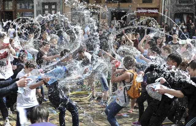 Ukrainians pour water on each other on a street in Lviv, Ukraine, April 13, 2015. The tradition of pouring water was an ancient spring ritual of cleansing on first Monday after Orthodox Easter. (Photo by Ivan Boberskyy/EPA)