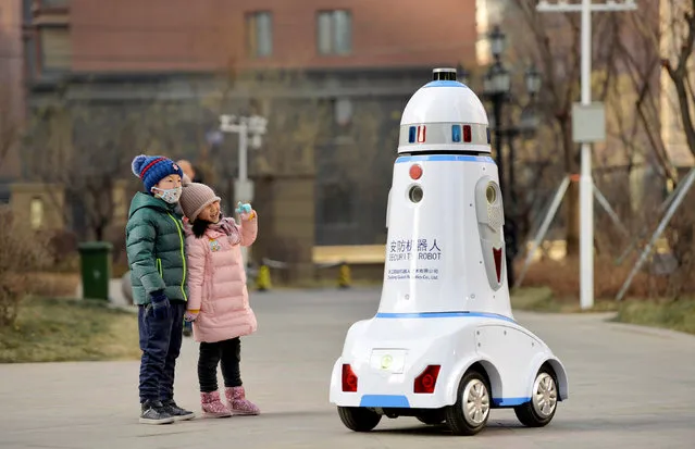 Children react next to a security robot patrolling inside a residential compound in Hohhot, Inner Mongolia, China January 18, 2019. (Photo by Reuters/Stringer)
