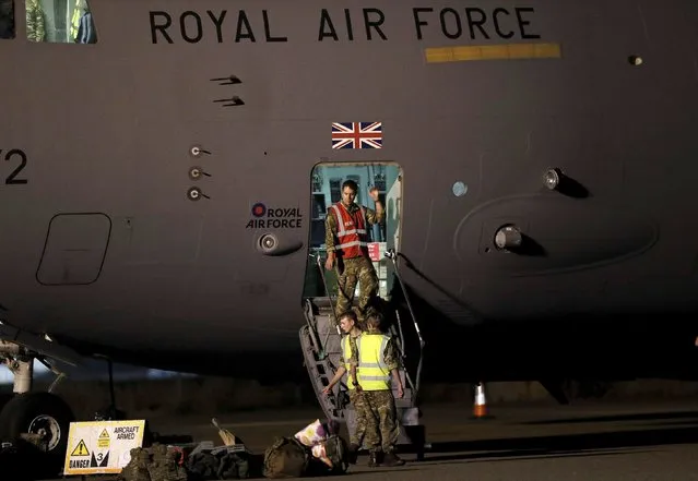 British military personnel depart a C-17 aircraft at RAF Brize Norton, Oxfordshire, late Sunday, August 29, 2021. The final UK troops and diplomatic staff were airlifted from Kabul on Saturday, drawing to a close Britain's 20-year engagement in Afghanistan and a two-week operation to rescue UK nationals and Afghan allies. (Photo by Peter Nicholls/Pool Photo via AP Photo)
