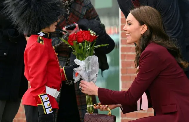 Prince William, Prince of Wales and Catherine, Princess of Wales receive flowers from Henry Dynov-Teixeira, 8, as they depart Greentown Labs, which bills itself as the world's largest climate technology startup incubator, in Somerville, Massachusetts, December 1, 2022. (Photo by Angela Weiss/Pool via Reuters)